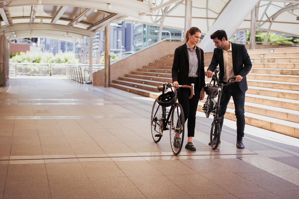 Commuting to work with bicycle. Businessman and businesswoman cycling to office in downtown district. Modern diversity people use eco transportation on city street. Environmental sustainable lifestyle